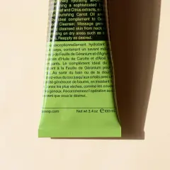 Zieleń tubki z tekstem w języku angielskim i francuskim. Analiza składu wskazuje na geranium, cytrusy i marchew.